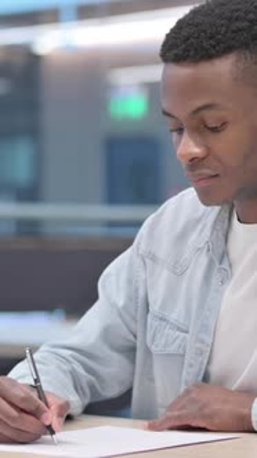 Pensive African Man Writing on Paper, Thinking , Vertical Video