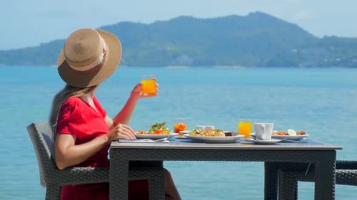 Young Woman Relaxes in Luxury Hotel Enjoying Breakfast with Healthy Food