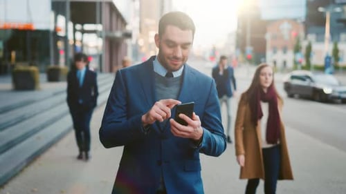 Man Using Smartphone on Busy City Sidewalk