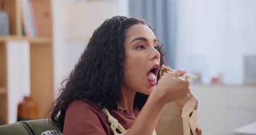 Woman Enjoys Takeout Meal with Chopsticks at Home