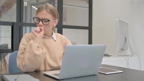Coughing Female Worker Using Laptop in Office