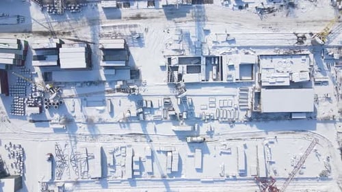Betonmischer in der Nähe des Versandcontainers auf dem Lagerplatz im Winter, Luftaufnahme von oben nach unten