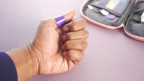 Hand with Adhesive Bandage on Thumb Close Up