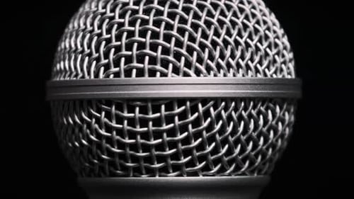 O microfone vocal gira lentamente em um fundo preto