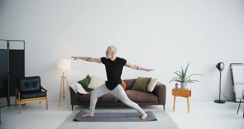 Man Practices Yoga in Living Room