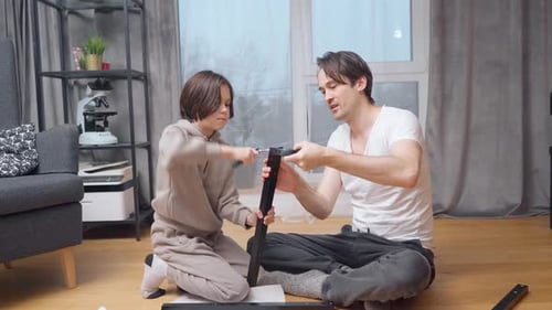 Dad and Child Assembling Furniture Together at Home
