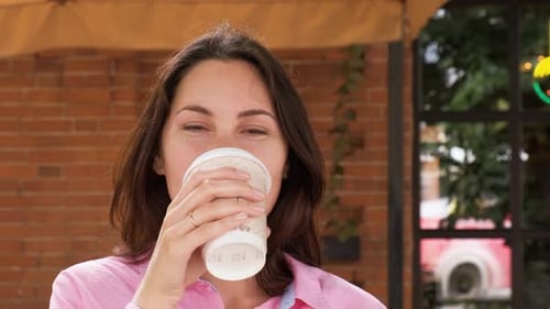 Woman Enjoys Coffee with Cheerful Smile Close-Up