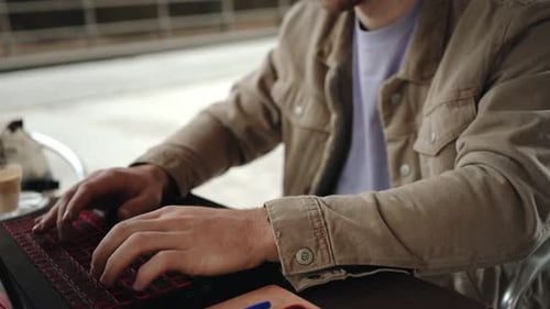 Focused Young Student Working on Laptop in University Campus Cafe