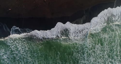 Ocean Waves Forming Textured Patterns Along Sandy Shore