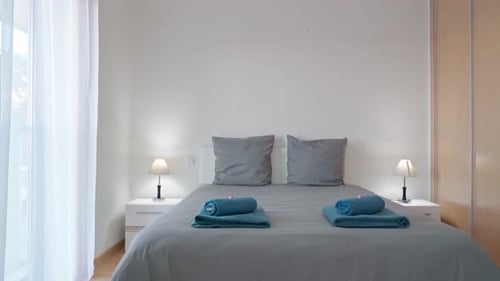 Modern Bedroom Interior with Neutral Colors and Blue Towels