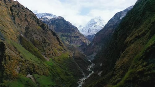 Aerial drone view flying through an epic mountain valley in the Annapurna Range of the Himalayas, Ne