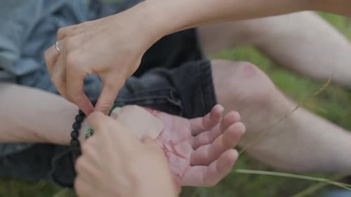 Nurse Applying Bandage on Injured Hand of Patient Outdoors