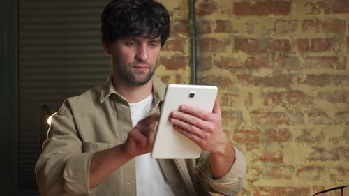 Young Adult Man Using a Tablet Indoors
