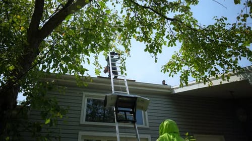 Roofer Installing a New Roof on an House Using Special Lifting Devices