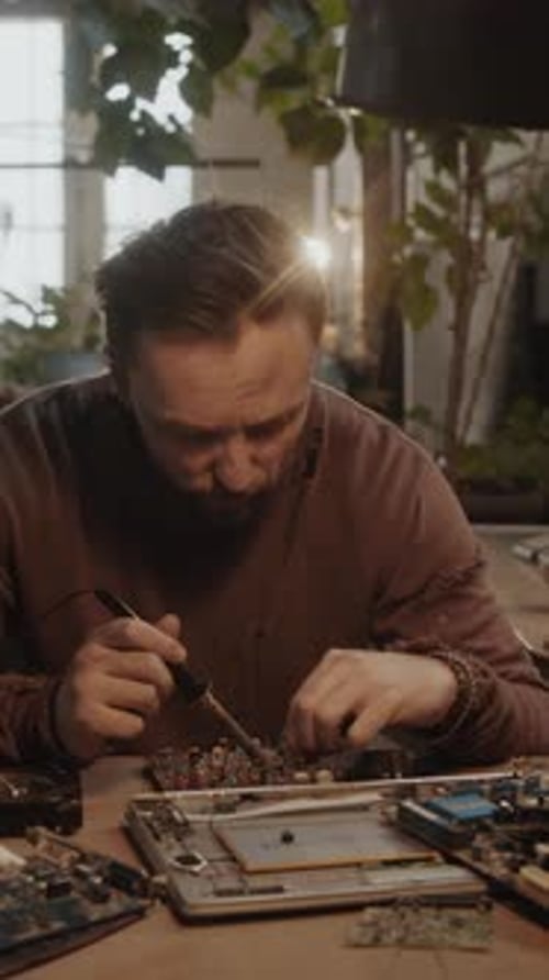 Focused Technician Repairing Intricate Circuit Board with Care