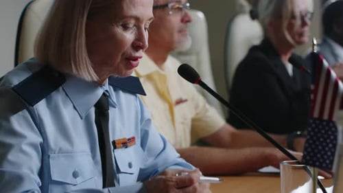 Adults Sitting at Conference Table Listening to Speaker