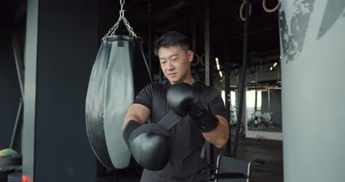 Man Putting On Boxing Gloves in Gym