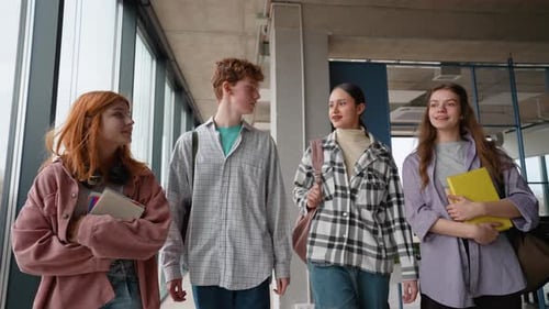 Group of Happy Young Teenager Students Walking with Books and Bags at University