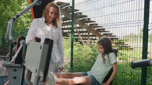 Parent and Child Practicing Exercises Safely in Leafy Park Setting Caring Mother Patiently Instructs