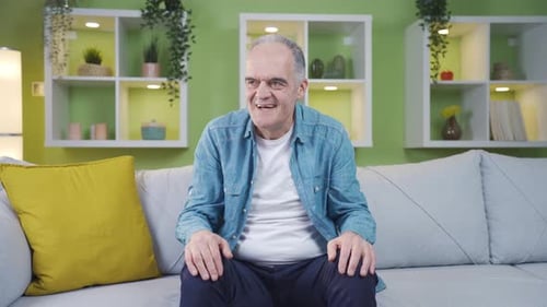 Smiling Man Chatting on Sofa at Home