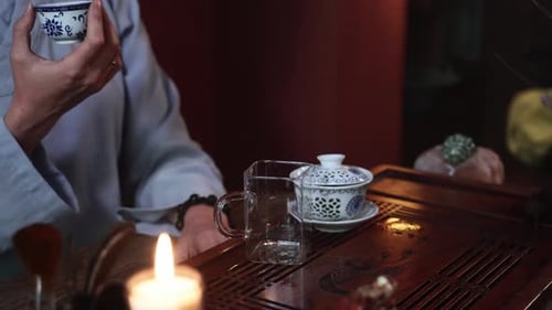 Tea Ceremony Female Tea Master in a Kimono Drinks Puerh From a Bowl While Sitting at a Table Indoors