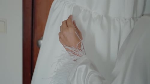 Woman Touching a Wedding Dress in Bridal Robe