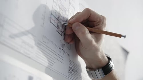Architect Writes on a Drawing Hanging on the Wall Closeup