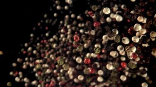 Multi Colored Peppercorns Swirling on Black Background
