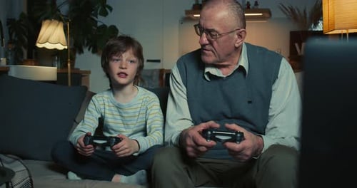 Child and Senior Man Play Video Game