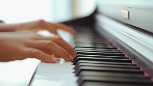 Child playing grand piano. Handheld shot. Close up.