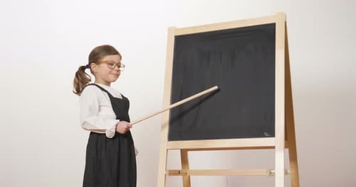 Young Girl Standing Next to Blackboard with Pointer