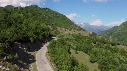 Cars driving on winding mountain road in summer