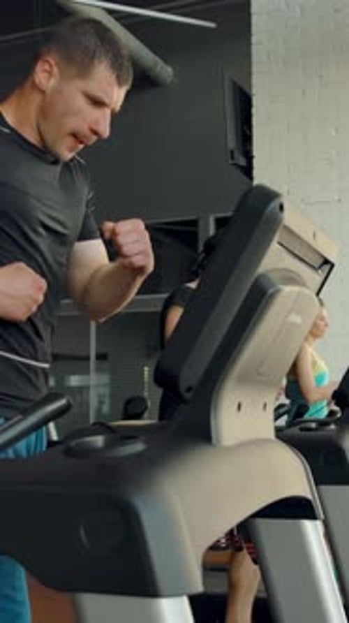 Man and Woman on Treadmills at the Gym