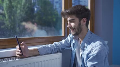 Man smiling at phone message.