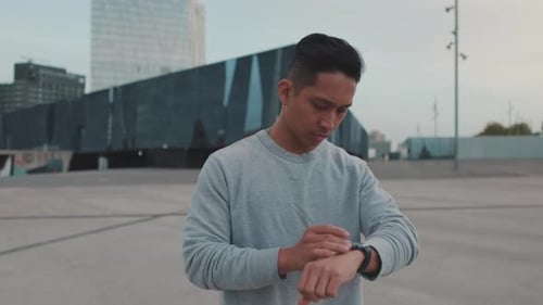 Young Adult Using Smartwatch in Urban Setting