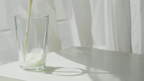 The Mesmerizing Pouring of Morning Milk Into a Transparent Glass