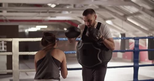 Woman Boxing with Coach in Boxing Ring