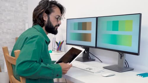 Man Working at Desk With Two Monitors