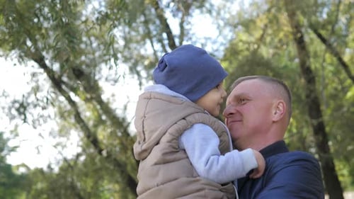 Grandfather and 2Year Old Grandson Having a Nice Hugging in City Park in the Autumn Day