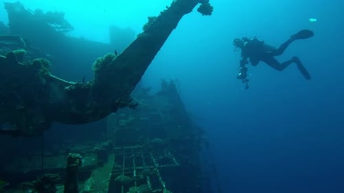 Scuba diver swimming next to superstructure on wreckship of Salem Express