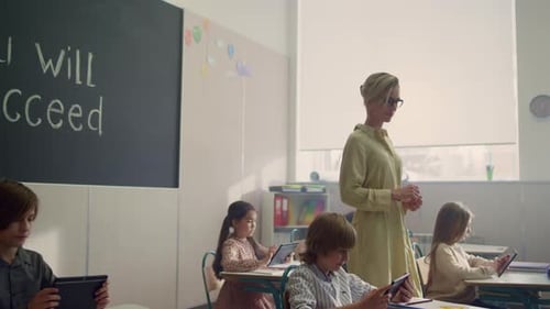 Multi Ethnic Pupils Using Tablet Computers in School Class. Diverse Group Of