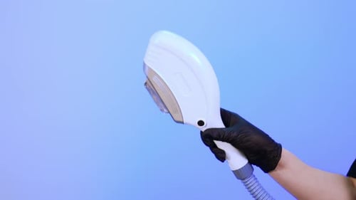 Gloved Hand Holding Laser Hair Removal Device