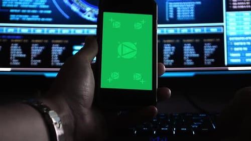 Hacker using a smartphone in front of hi-tech screens, motion-tracked for easy screen replacement
