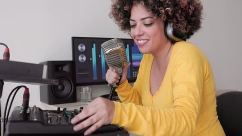 African singer recording song at music production home studio - Audio engineer woman mixing album