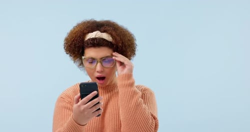 Wow, surprise and woman with phone in studio for fake news, drama or wtf text on blue background
