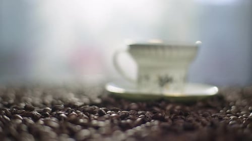 Coffee Pouring Into Cup on Coffee Beans
