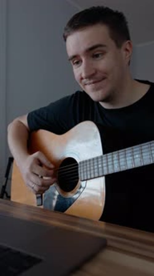 Man Playing Acoustic Guitar at Home