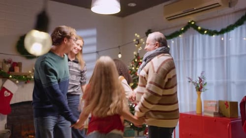 Family Joyfully Dancing Around Christmas Tree