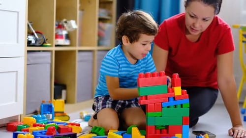 Madre jugando con bloques de plástico de colores con su hijo Concepto para madre e hijo jugando juntos