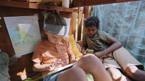 Boys Playing with Technology in Playhouse